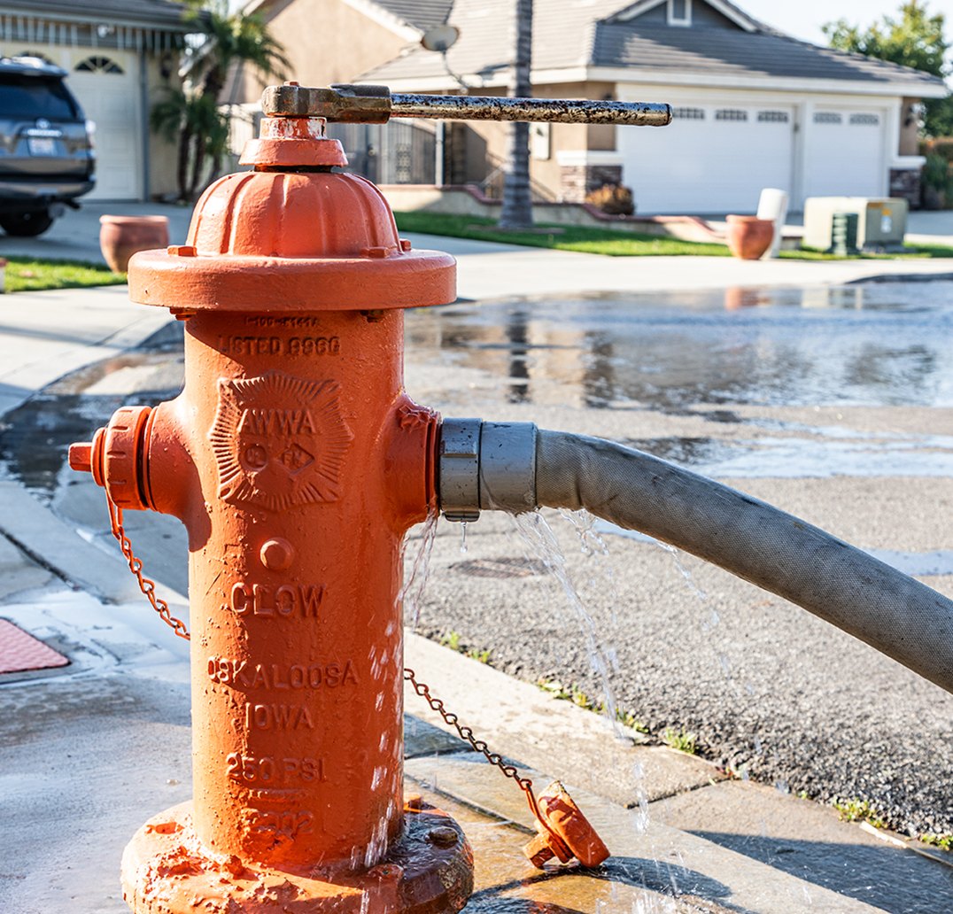 Hands using a tool to open up a fire hydrant